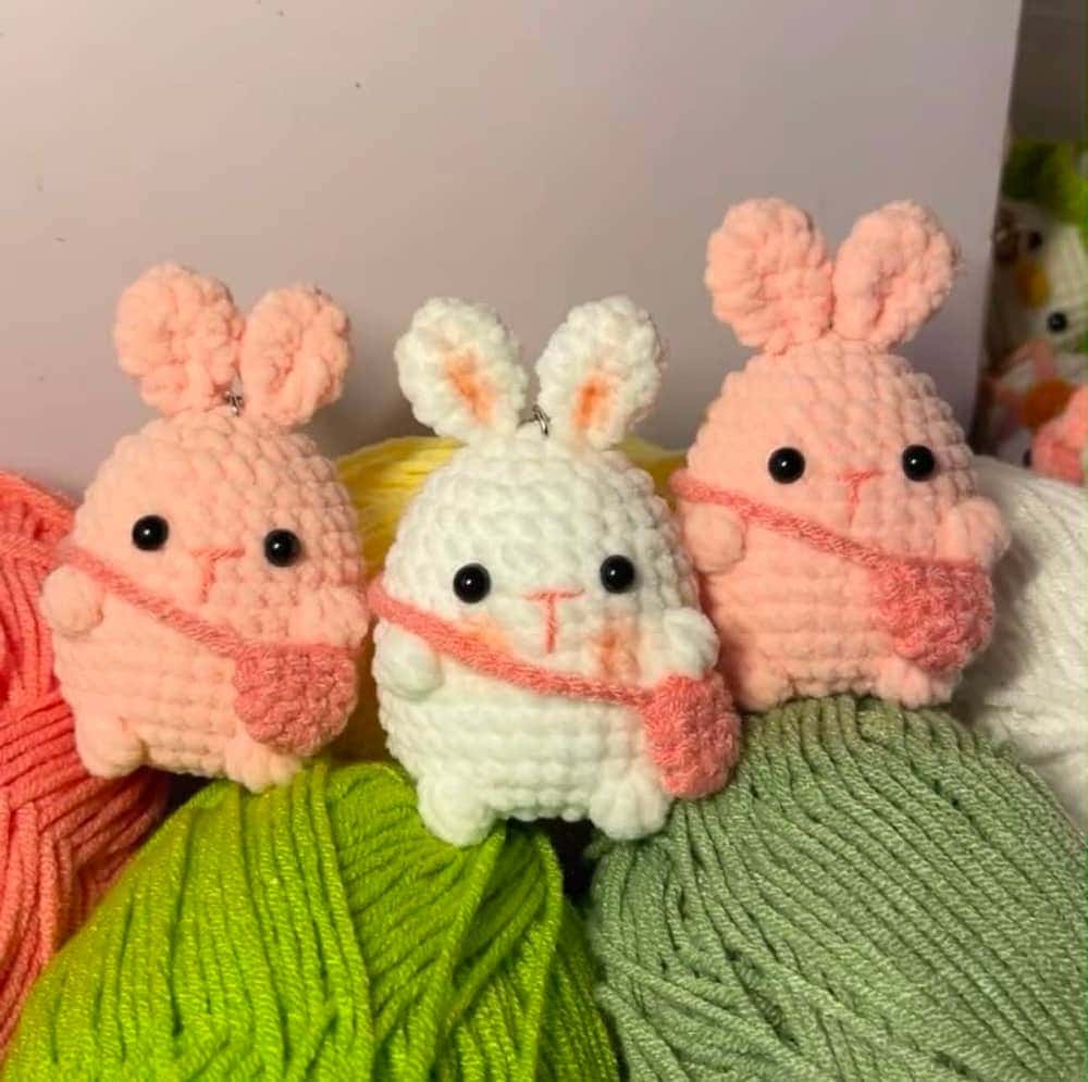 Móc khóa len thỏ con handmade với khoen vàng trên nền hồng nhạt